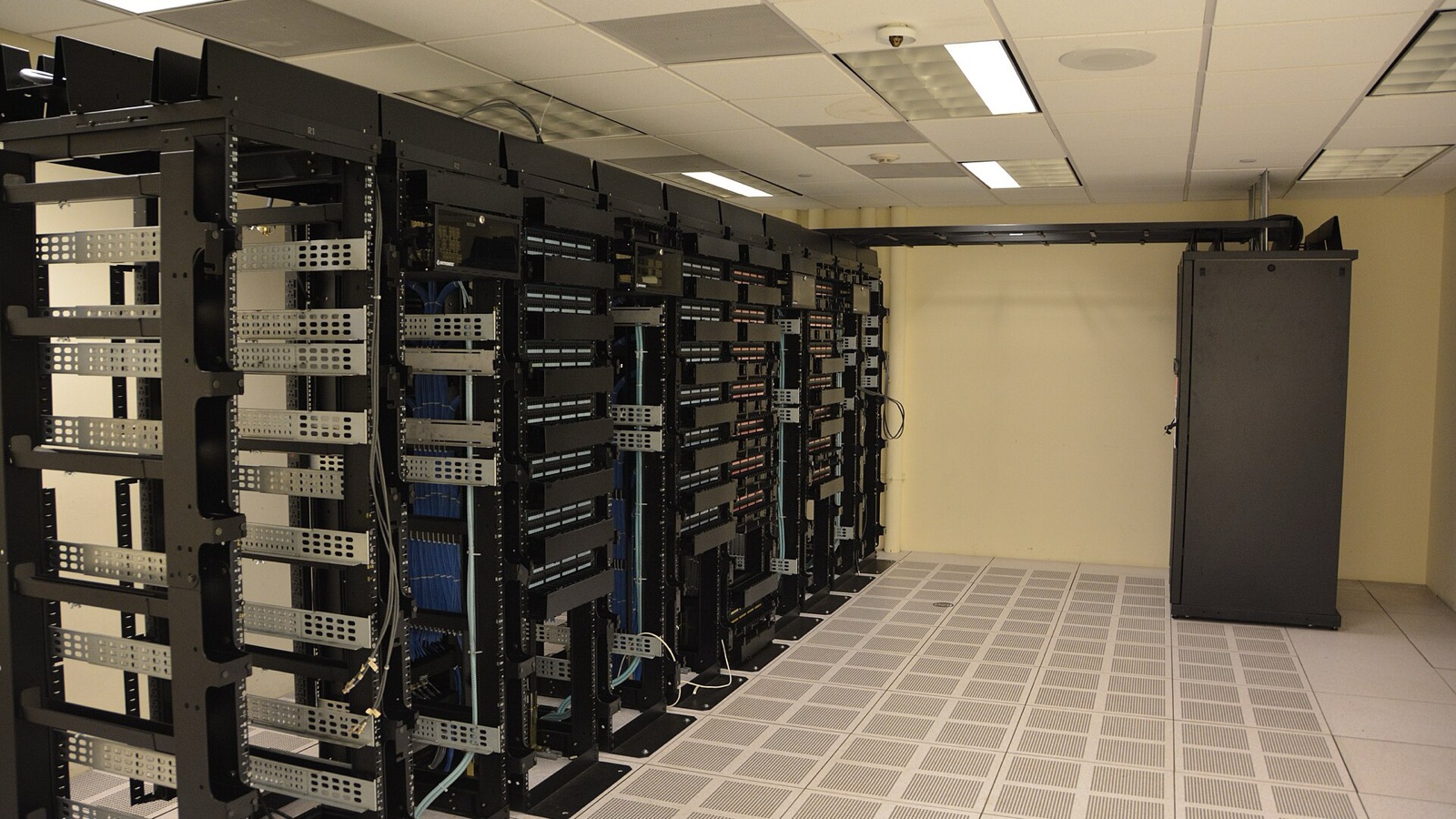 Rows of server racks inside a working data centre, illustrating the infrastructure behind AI cloud computing.
