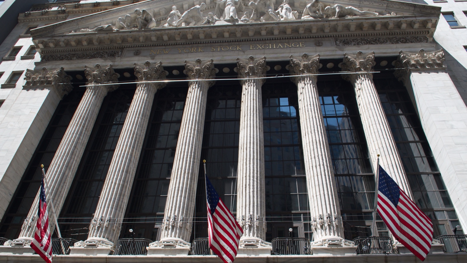 The neoclassical facade and American flags at the New York Stock Exchange on Broad Street