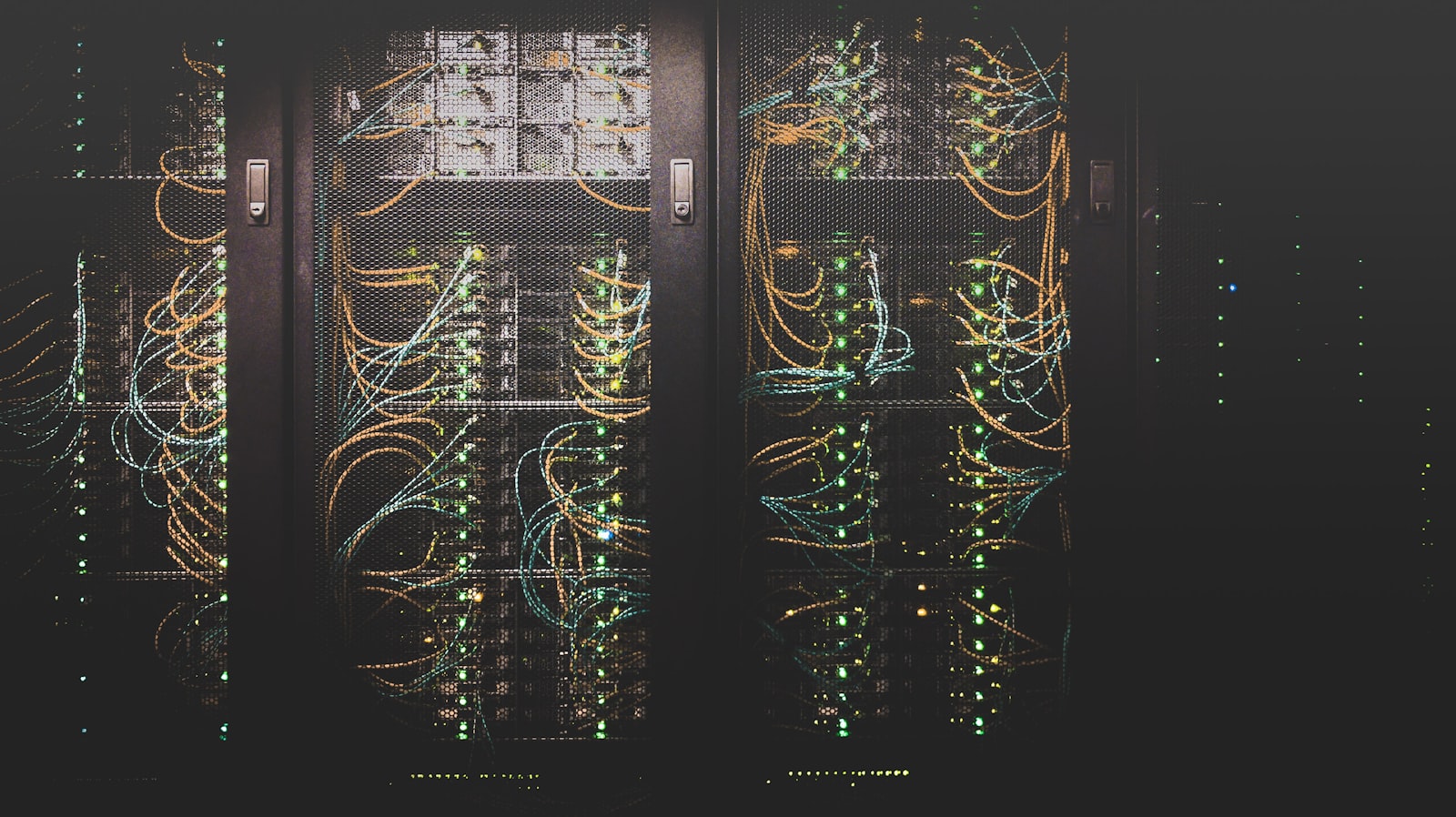 Rows of data-center server racks glowing with status lights and network cabling