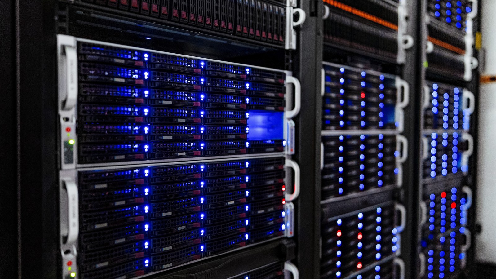 Illuminated server racks in a computer room, representing AI-cloud infrastructure