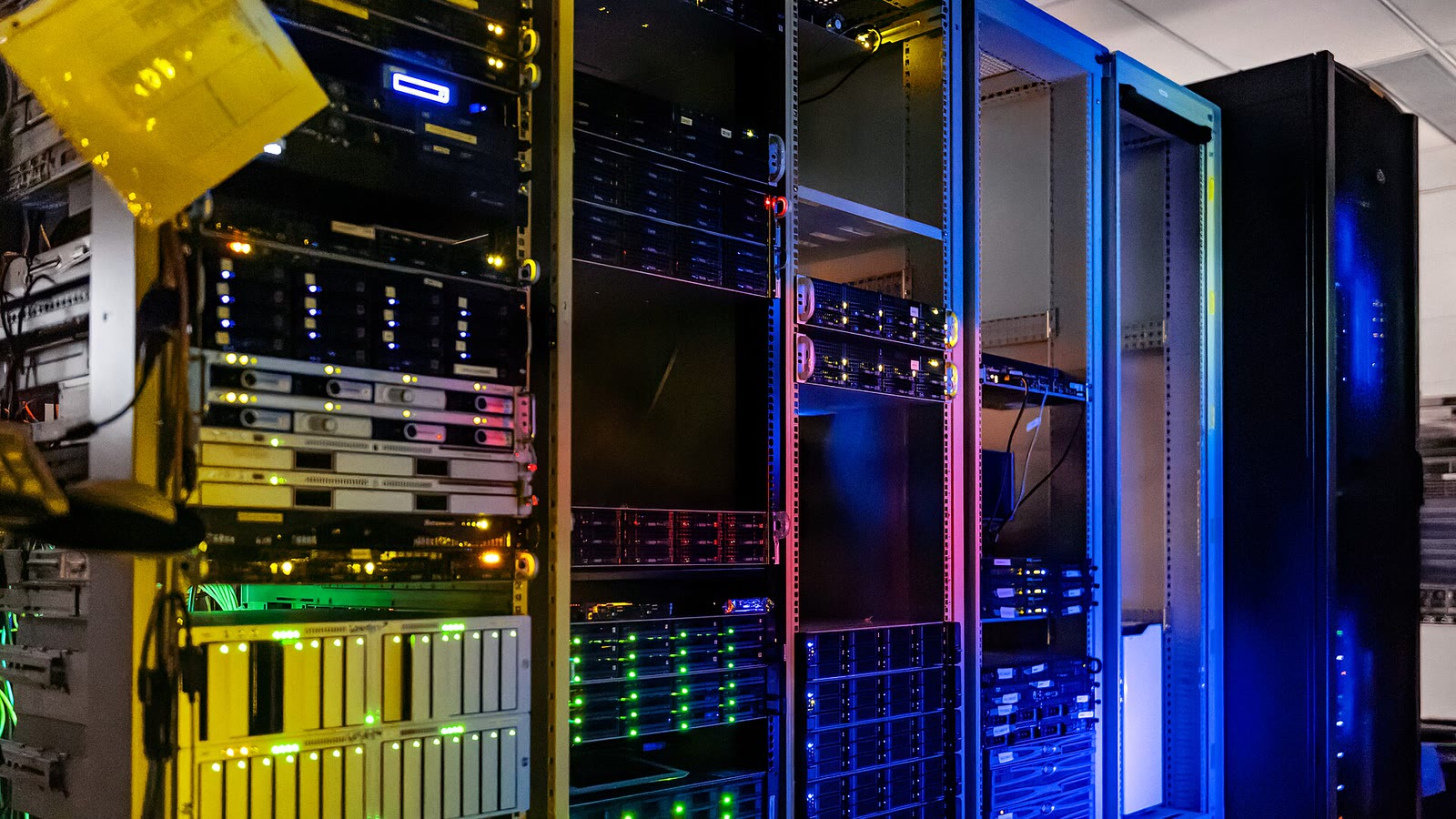Des rangées de serveurs informatiques éclairés dans le centre de données du siège de NOIRLab à Tucson