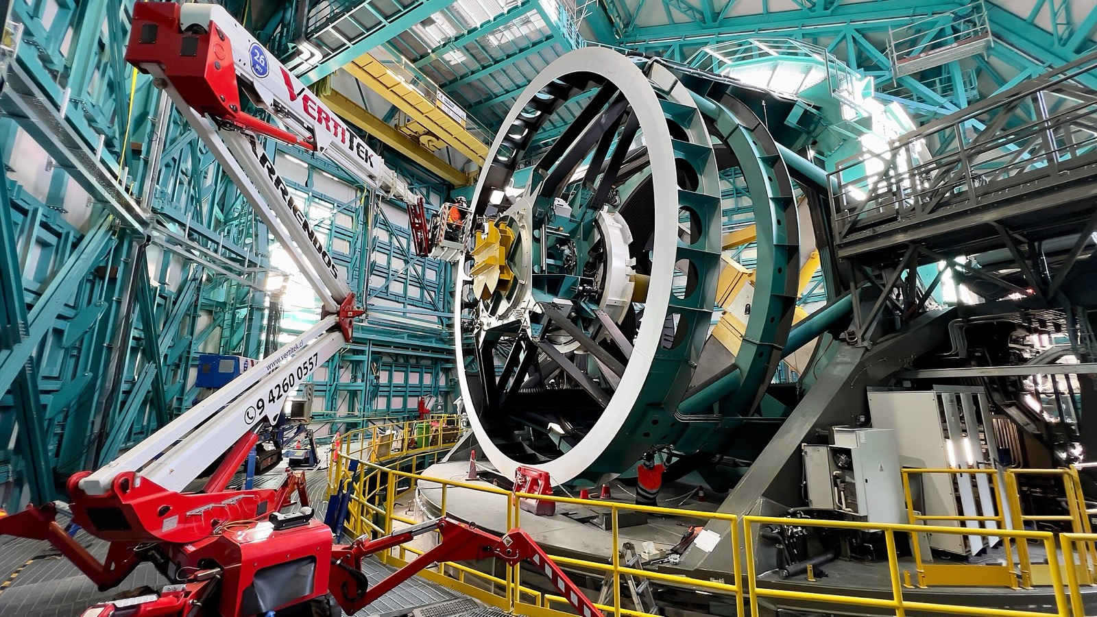 Un technicien réseau installe des câbles à fibre optique sur le télescope de l’observatoire Rubin
