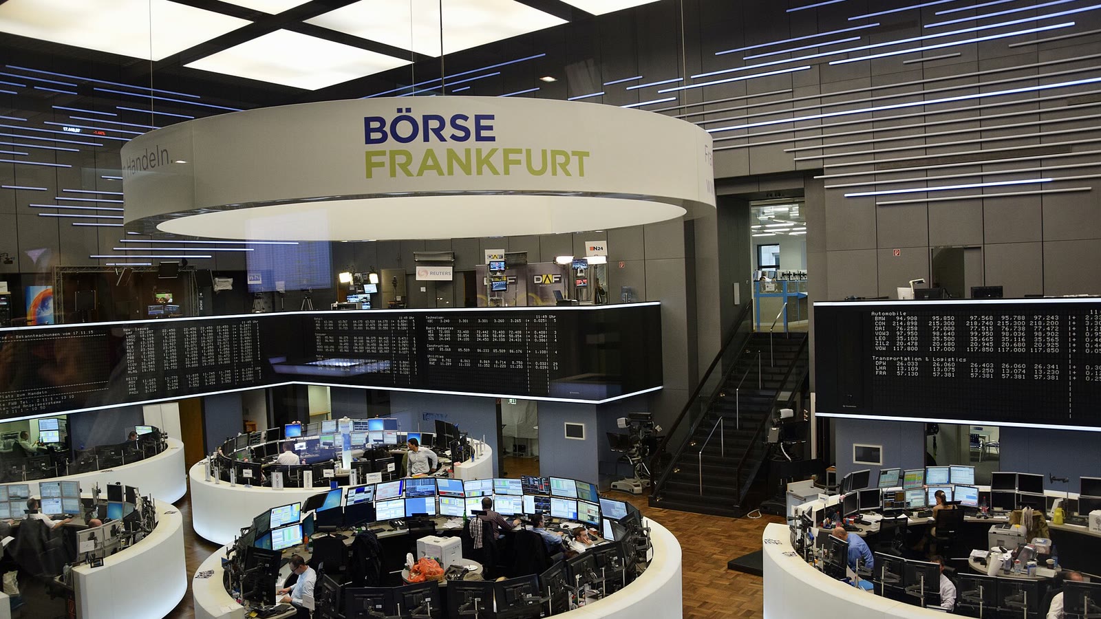 Traders and monitor banks beneath the Börse Frankfurt sign on the Frankfurt Stock Exchange floor