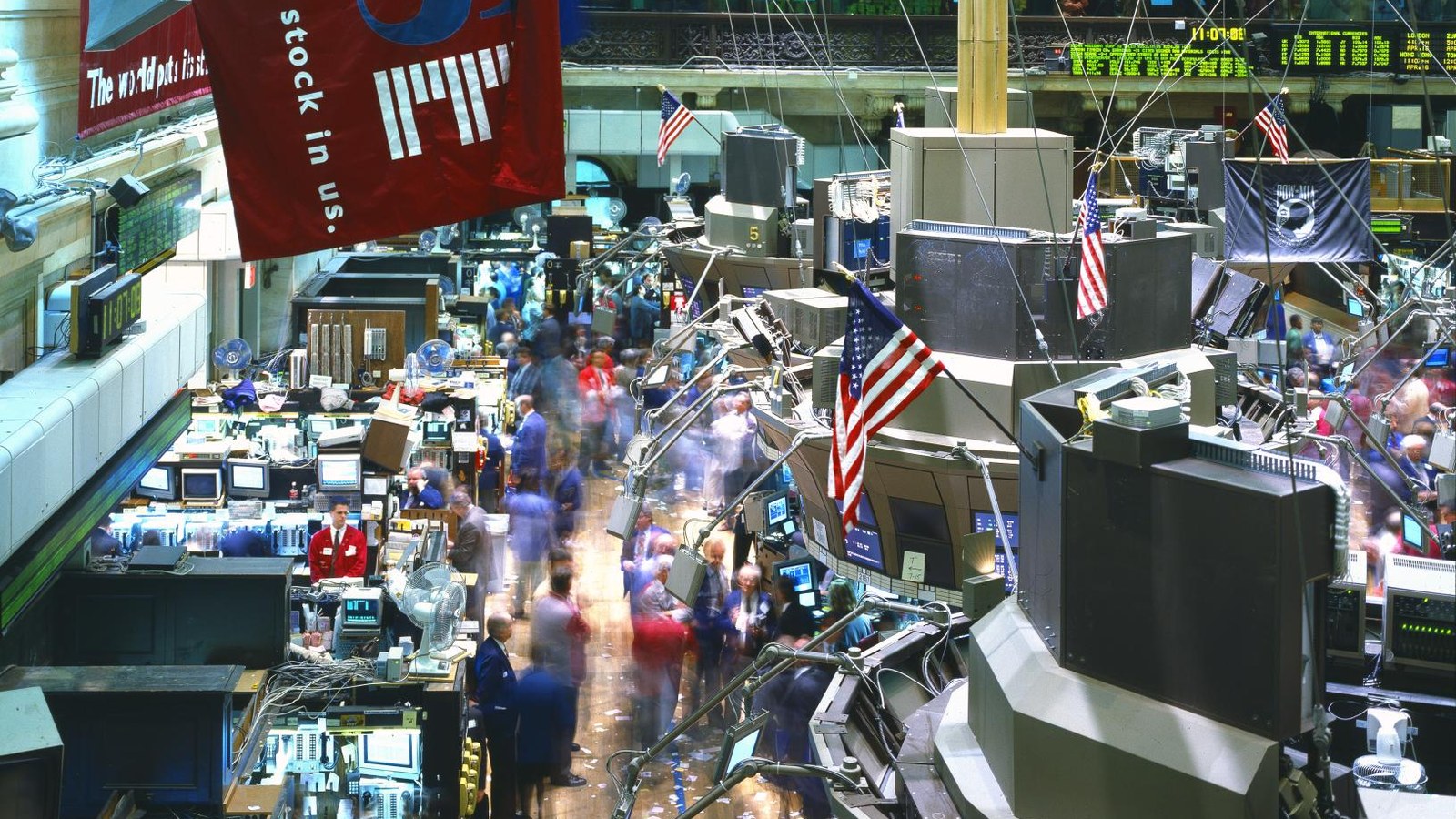 Traders move between crowded workstations and market screens on the New York Stock Exchange floor