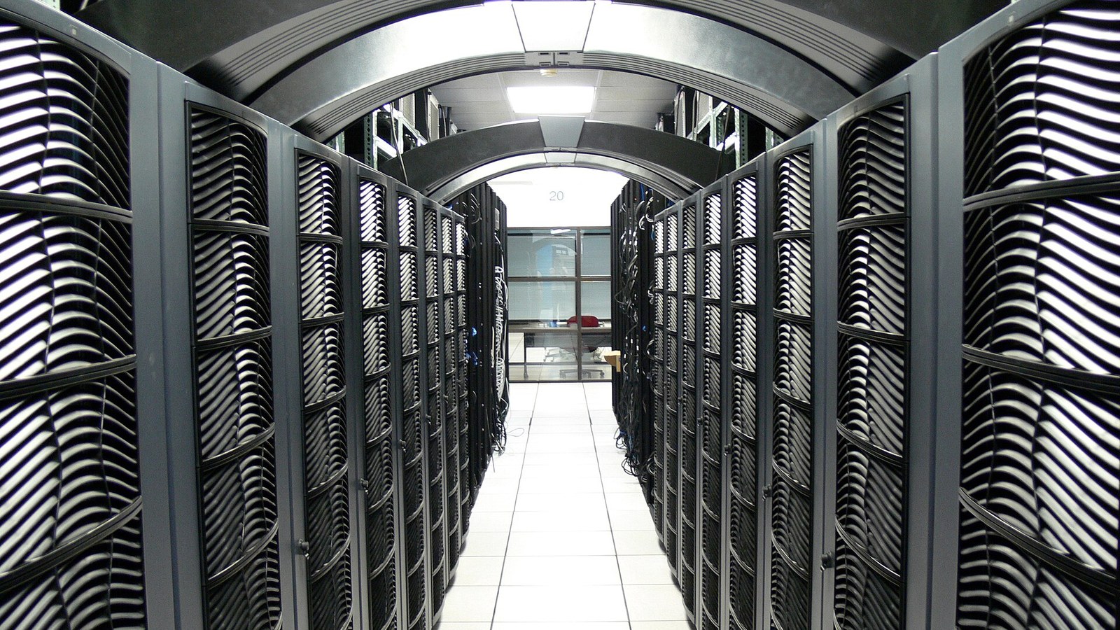 Rows of illuminated server racks inside a university data center aisle