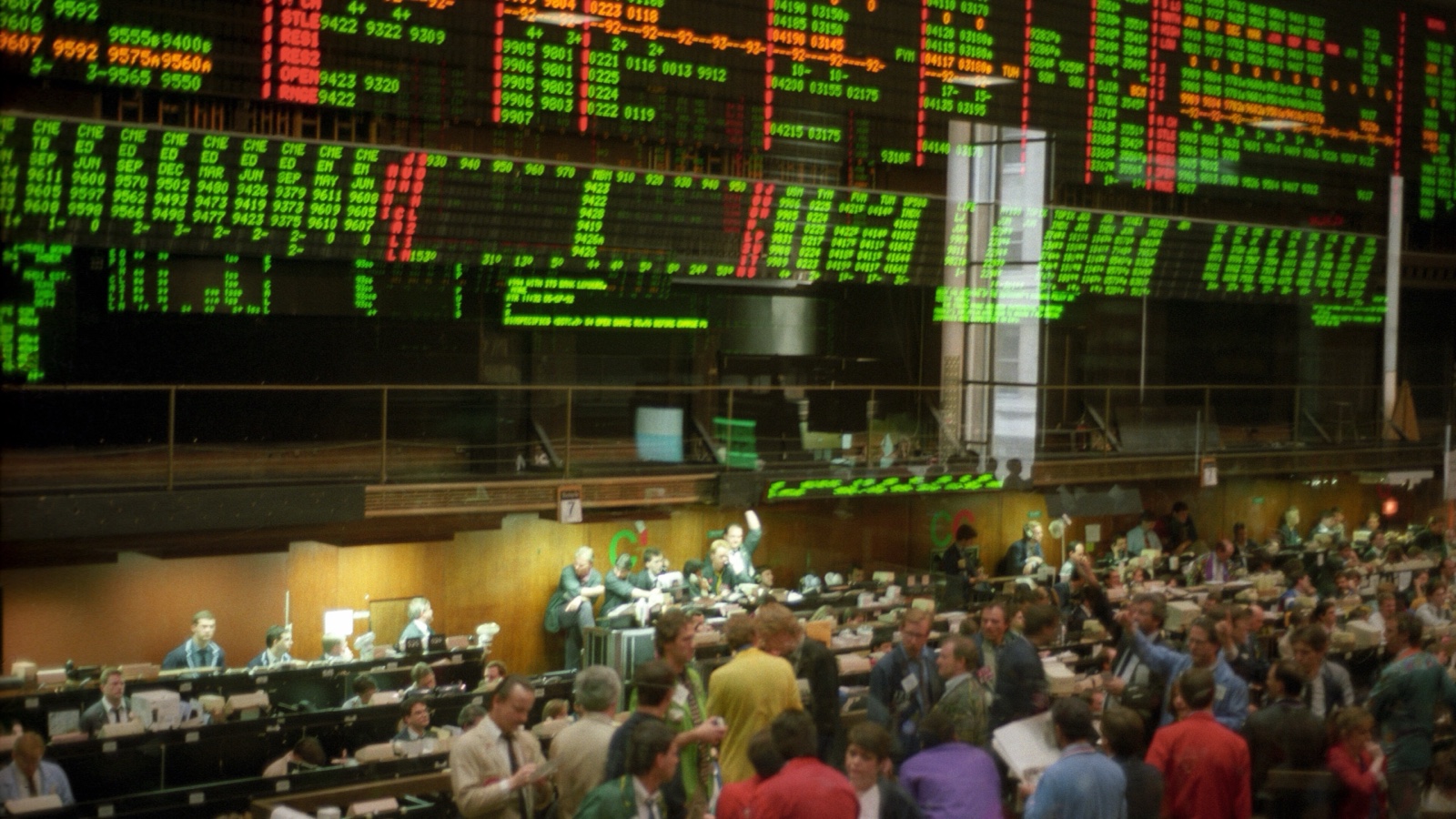 Un parquet animé du Chicago Board of Trade sous des tableaux électroniques rouges, verts et orange