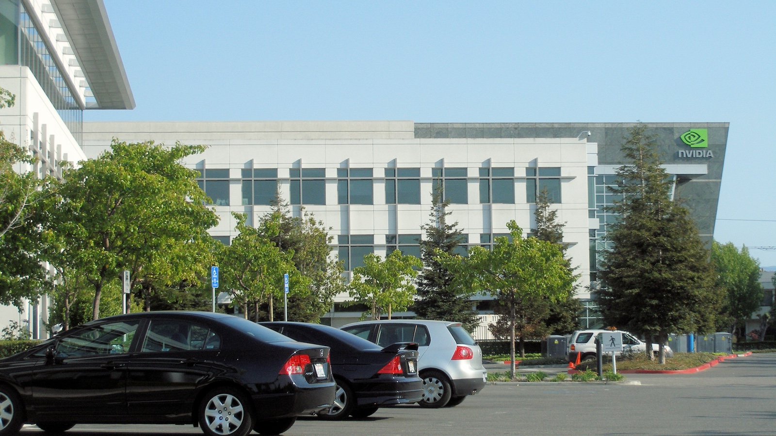 NVIDIA headquarters in Santa Clara, with the company sign above trees and parked cars