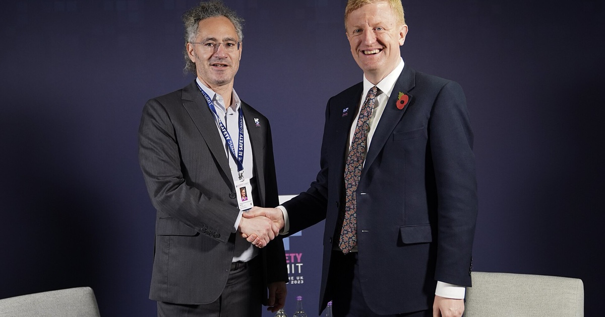 Alex Karp, PDG de Palantir, et Oliver Dowden, vice-premier ministre britannique, se serrent la main au sommet sur la sécurité de l’IA en 2023.