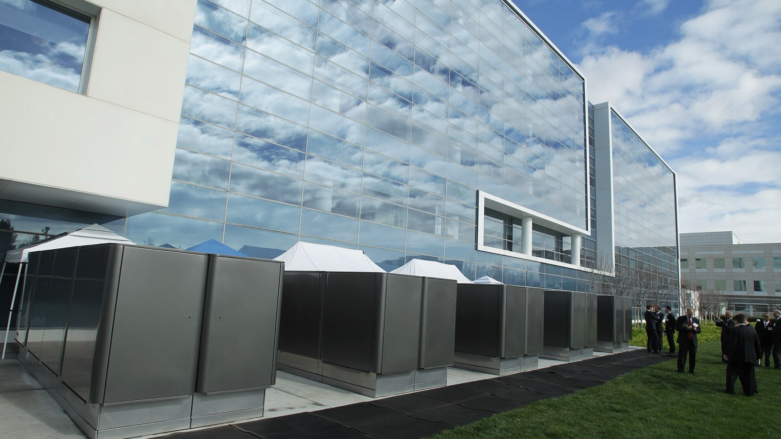 A row of Bloom Energy server units outside a glass office building