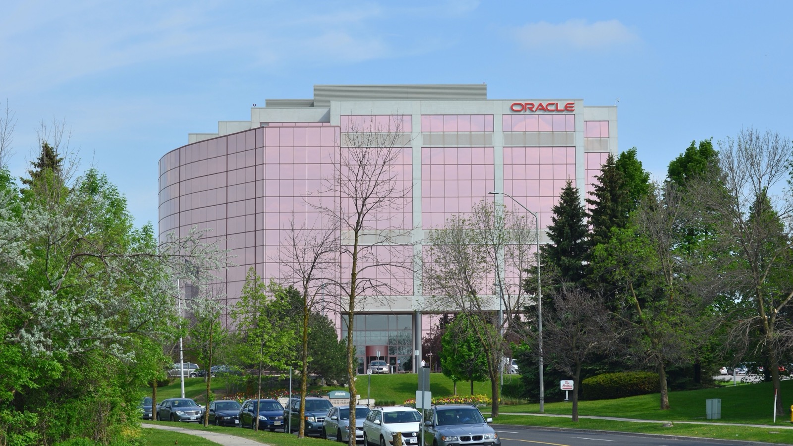 Oracle Canada office building in Markham framed by trees and a roadway.