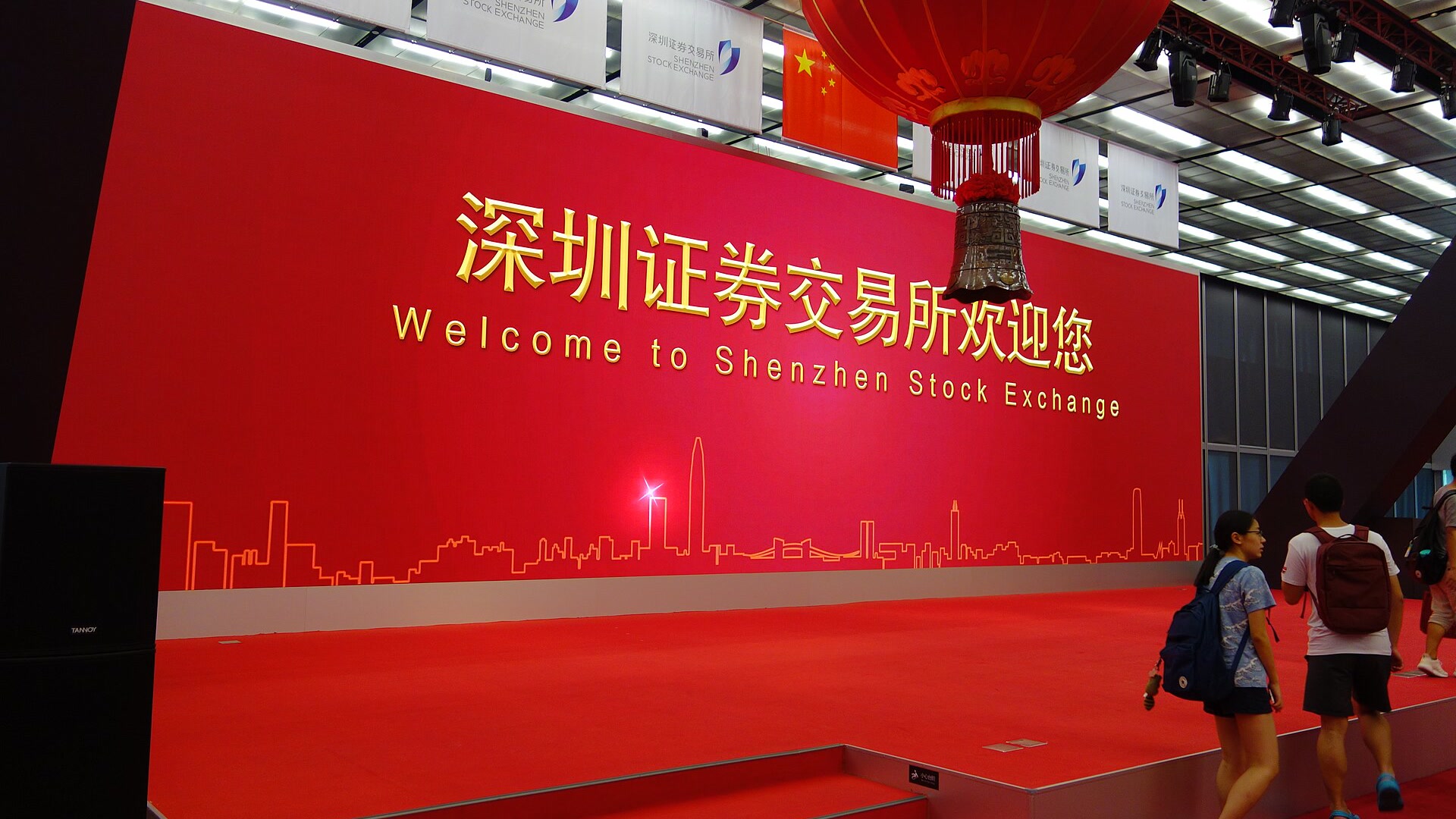 Red welcome wall and ceremonial bell inside the Shenzhen Stock Exchange hall
