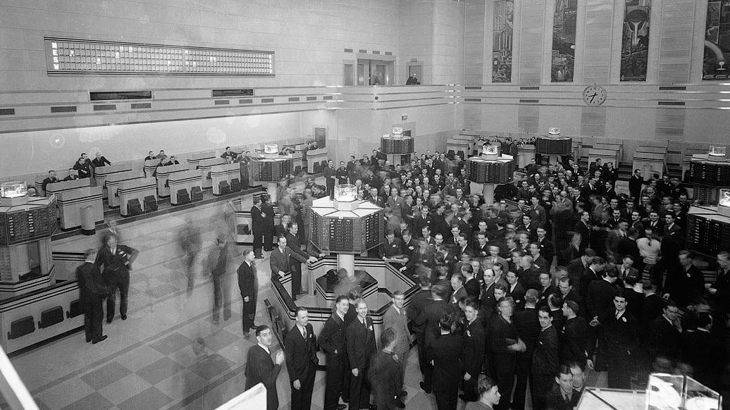 Historic Toronto Stock Exchange trading floor with trading posts and a broad crowd