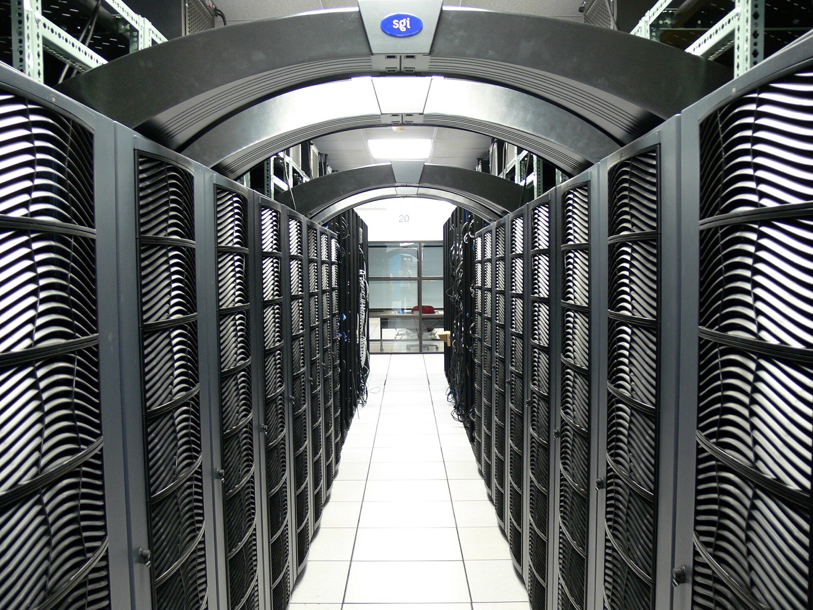 Aisle between rows of black supercomputer server cabinets in a university data center