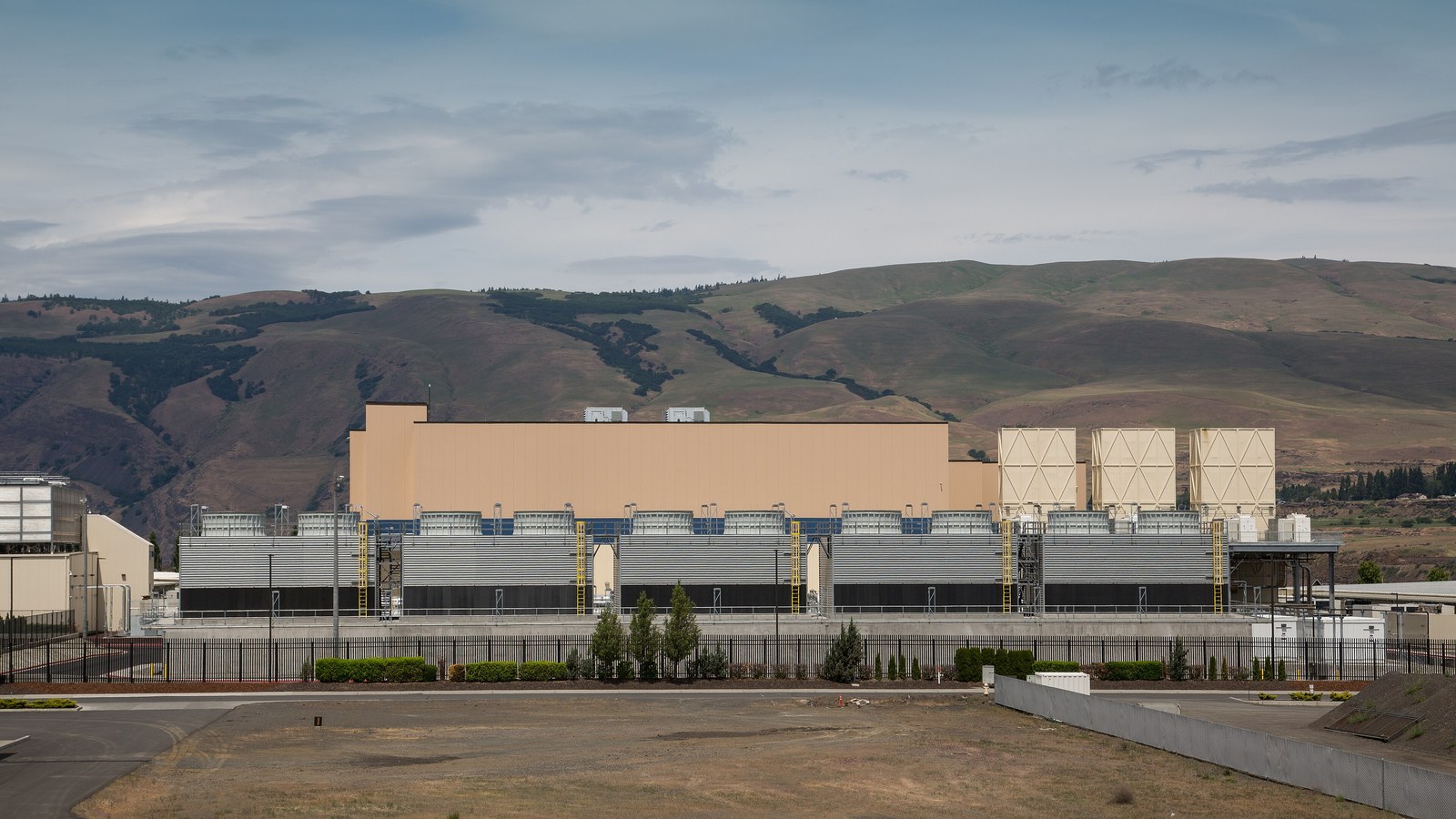 Exterior of Google's data-centre facility in The Dalles, Oregon, with cooling structures and hills in the background