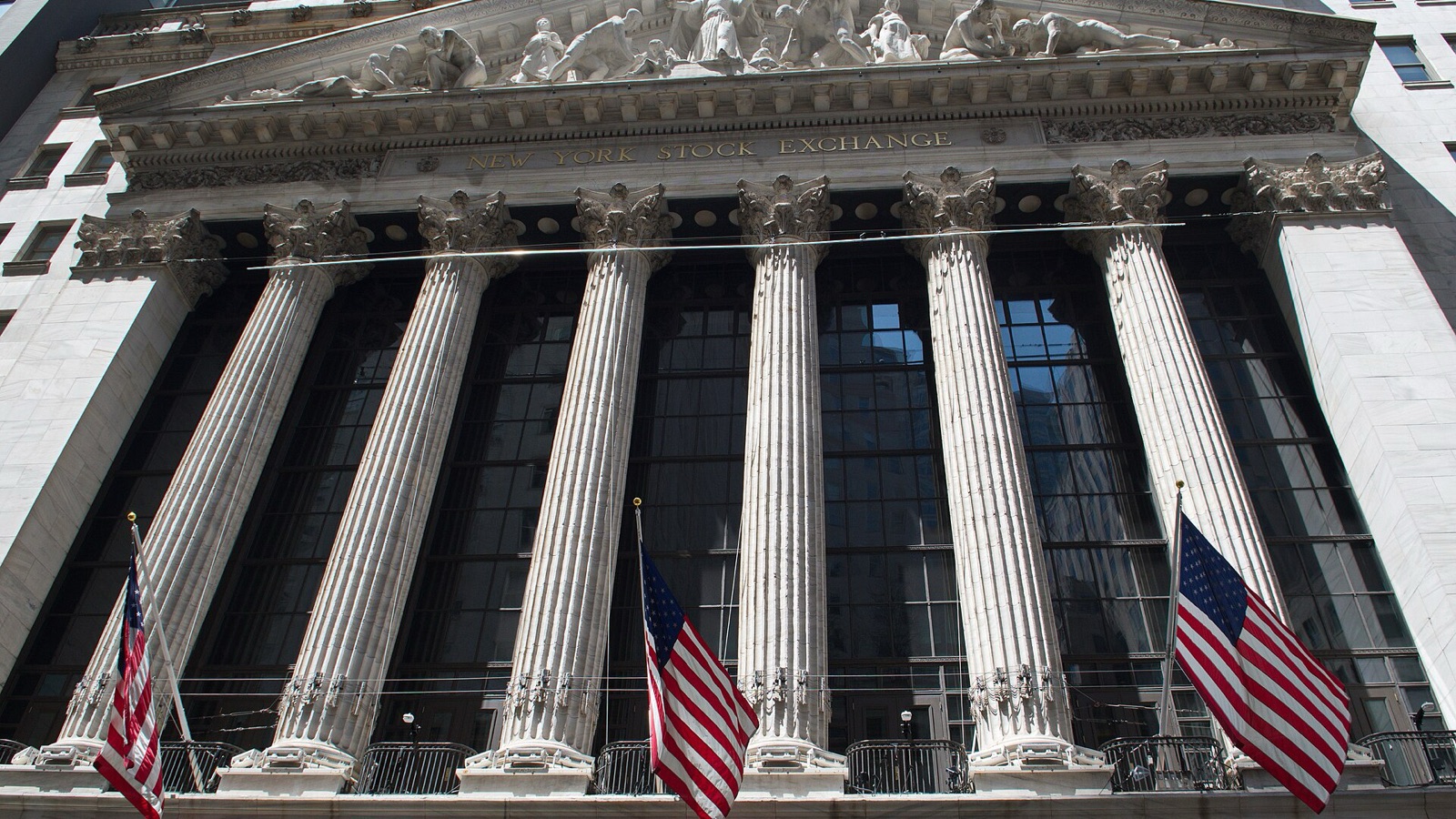 The New York Stock Exchange facade and flags, photographed in May 2024