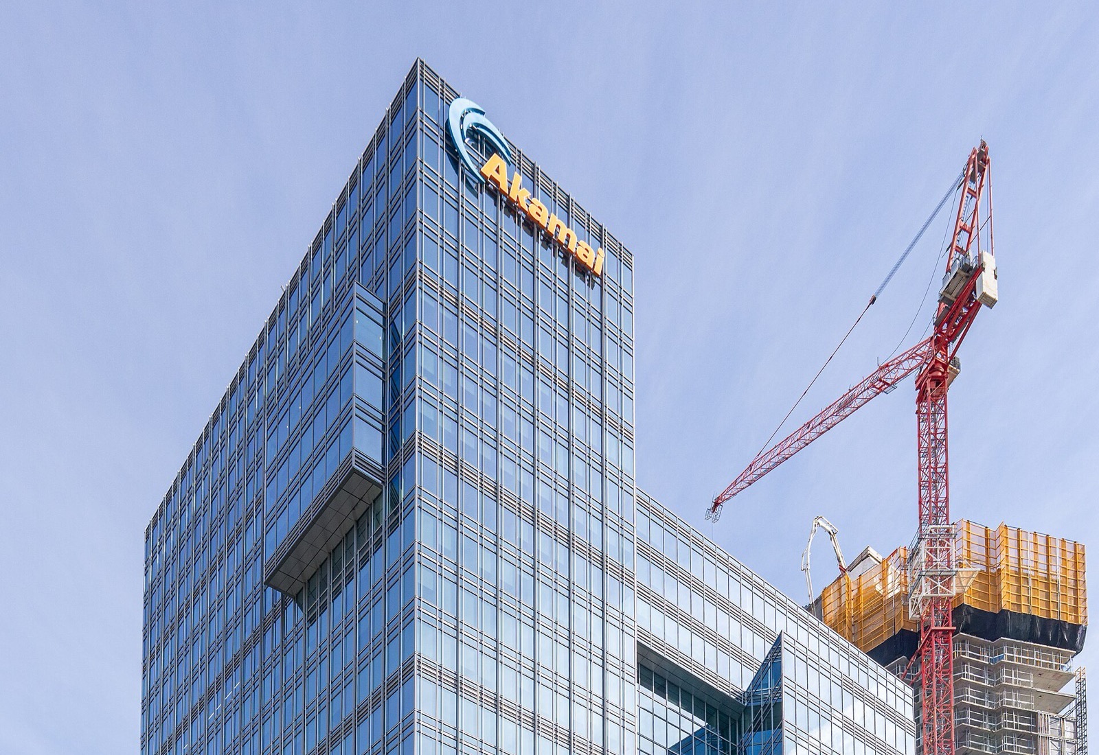 Akamai’s glass headquarters tower at 145 Broadway in Cambridge, Massachusetts, beside a construction crane on a neighbouring site