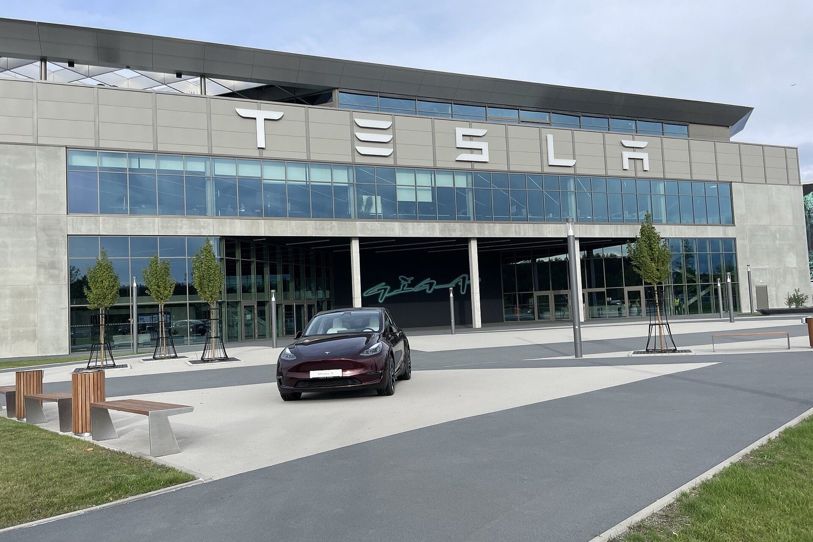 L’entrée de la Gigafactory de Tesla près de Berlin, avec le lettrage TESLA sur la façade et un Model Y bordeaux stationné devant