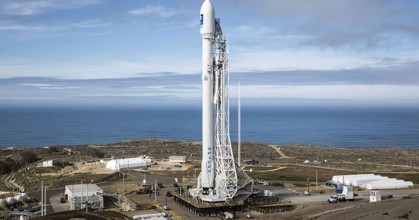 A Falcon 9 rocket stands on its launch pad above the Pacific Ocean at Vandenberg