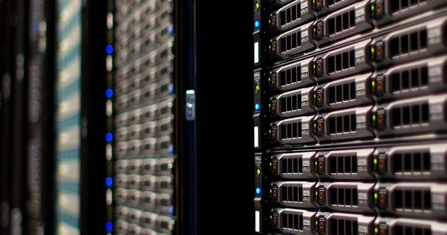 Close view down an aisle between occupied server racks in a data centre.