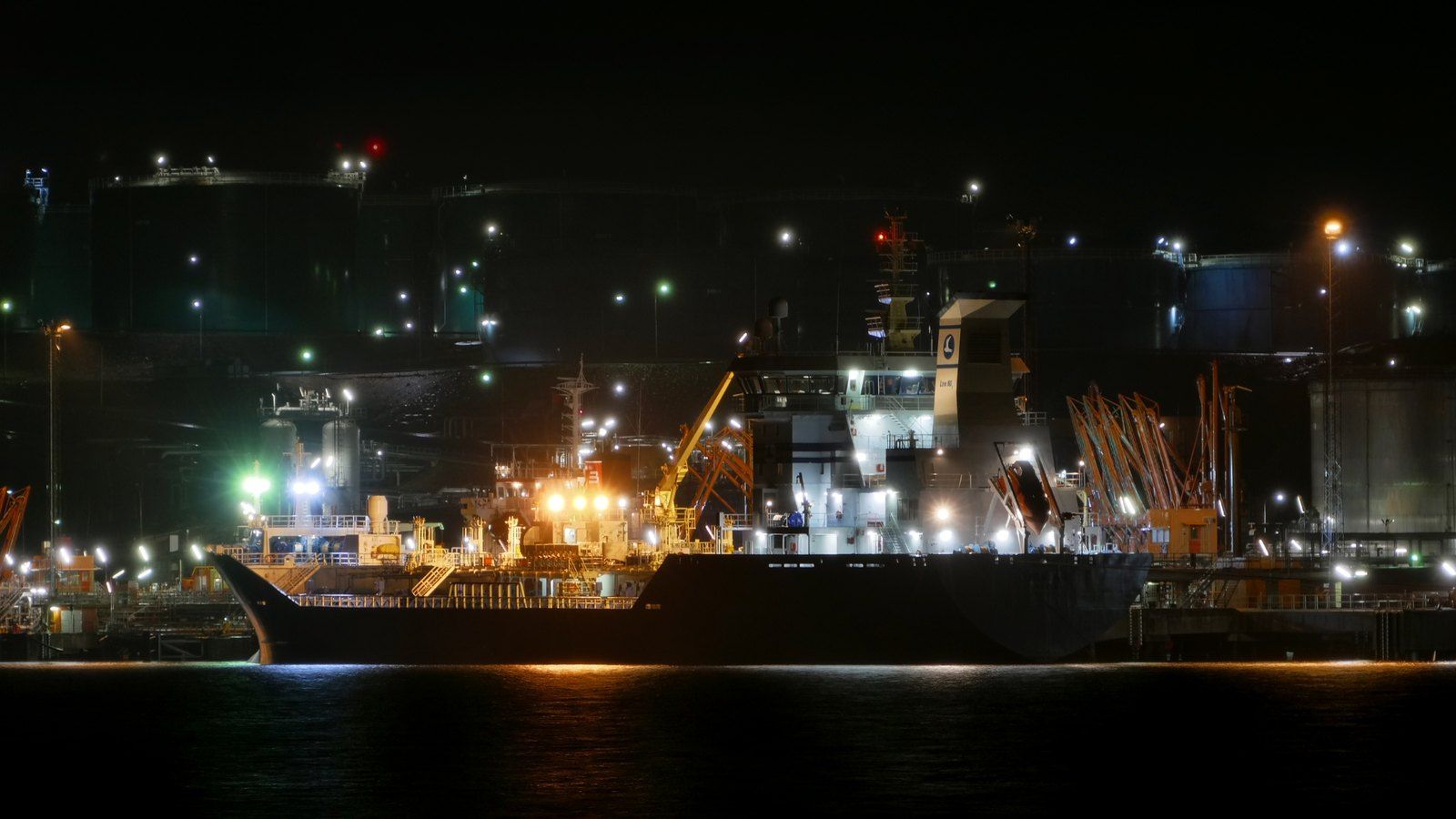 Tanker at the illuminated Preemraff Lysekil petroleum terminal in Sweden; archival oil-shipping photograph, not the Gulf