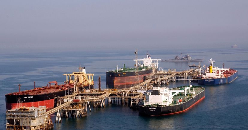 Pétroliers amarrés au terminal pétrolier d'Al Basra, dans le nord du golfe Persique, avec un croiseur de l'US Navy en patrouille à l'arrière-plan