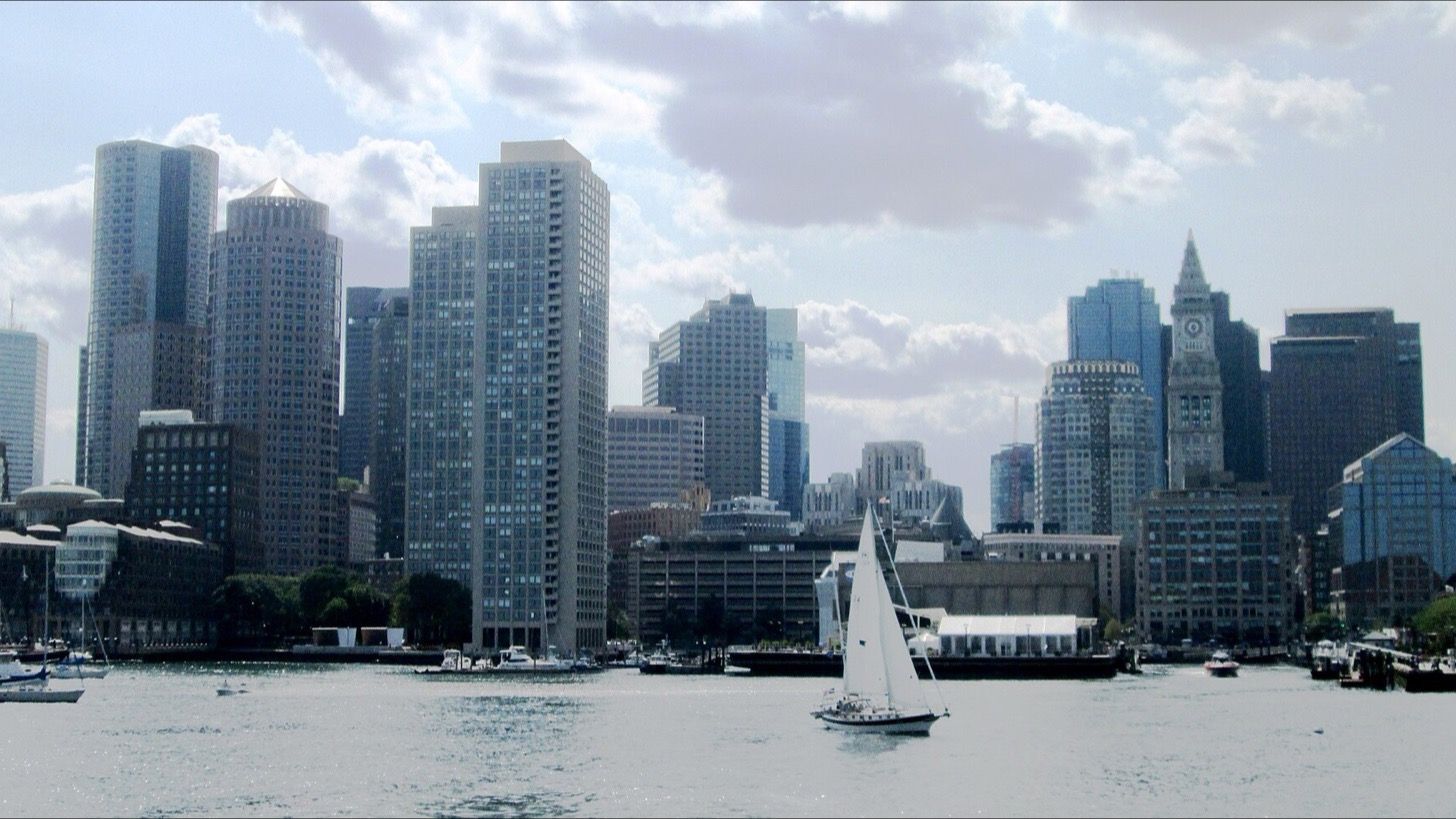 Boston’s skyline and a sailboat viewed from Boston Harbor