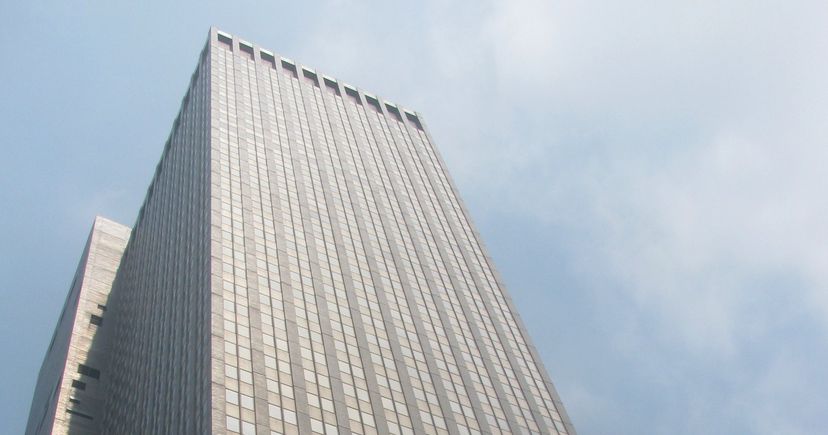 Archival July 2011 low-angle view of the upper facade of 245 Park Avenue in Manhattan, identified by the source as JPMorgan Asset Management, under a cloudy sky.