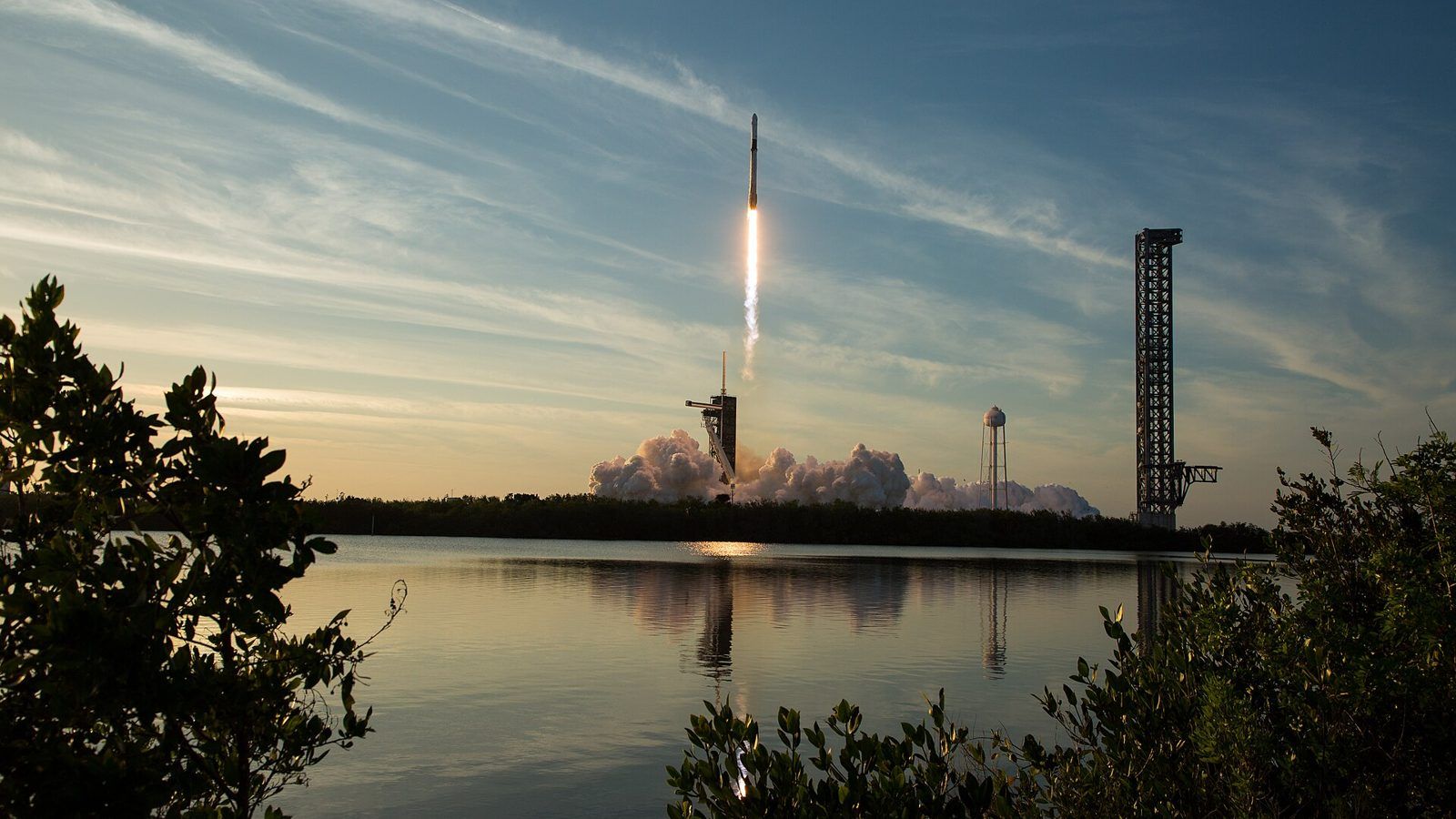 SpaceX Falcon 9 launches NASA's Crew-10 mission in March 2025, reflected across the water