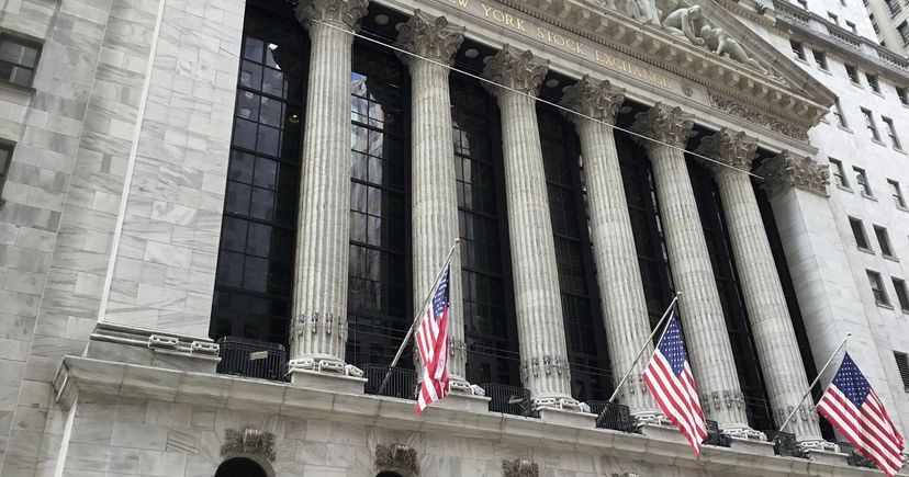 Photo d’archives de la façade en pierre de la Bourse de New York, avec ses colonnes et drapeaux américains.