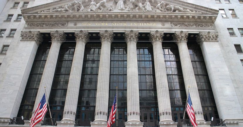 The New York Stock Exchange stone facade, columns and American flags