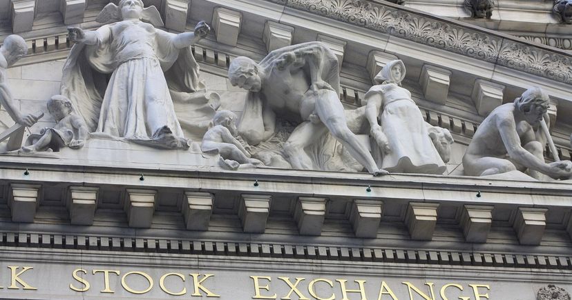 Carved stone figures and gold Stock Exchange lettering on the New York Stock Exchange facade.